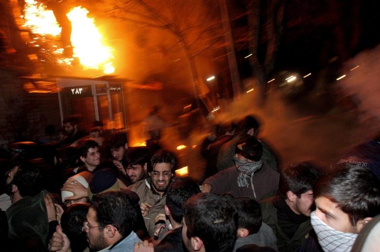 Politiet bruger tåregas mod demonstranterne, der kaster sten og brandbomber mod ambassaden. 