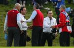 Molinari-brødrene giver hånd til  amerikanerne Stewart Cink og Matt Kuchar efter endnu en våd dag på kontoret. 