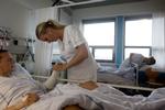 KNÆK. Sygeplejerske på Rigshospitalet Christine Larsen tilser Rene Hansen, der styrtede på motorcykel og brækkede et ben og en arm. 
