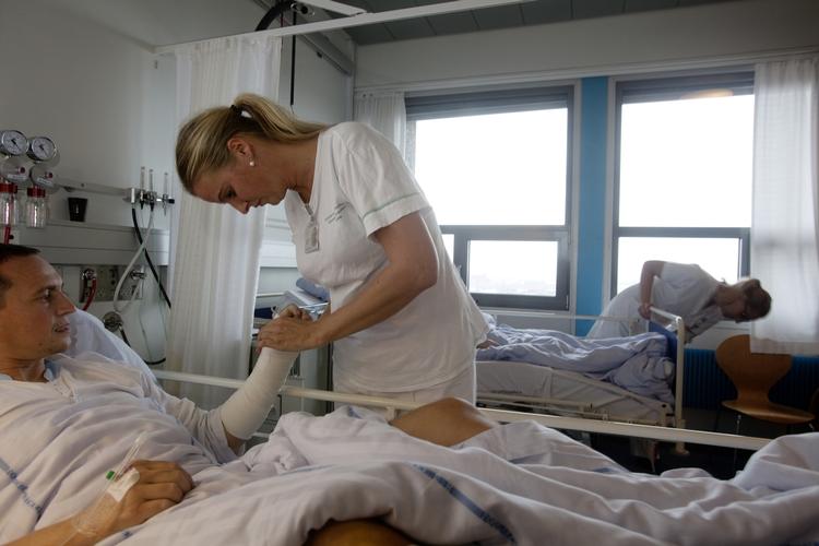KNÆK. Sygeplejerske på Rigshospitalet Christine Larsen tilser Rene Hansen, der styrtede på motorcykel og brækkede et ben og en arm. 