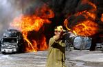TALEBANANGREB. Pakistansk brandmand fotograferet ved brændende Nato-tankvogne i Quetta i Pakistan onsdag morgen. 