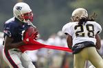 ustoppelig. New England Patriots' Randy Moss griber bolden, mens Usama Young fra New Orleans Saints kun kan trække wide receiverens trøje ud af form. Arkivfoto. 