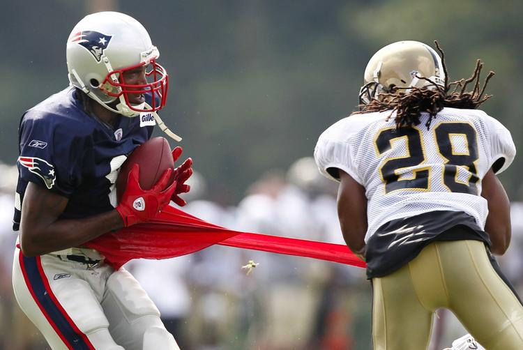 ustoppelig. New England Patriots' Randy Moss griber bolden, mens Usama Young fra New Orleans Saints kun kan trække wide receiverens trøje ud af form. Arkivfoto. 