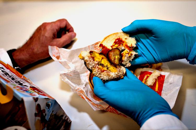Den ti dage gamle cheeseburger fra McDonalds (nederst til venstre) ser fin og relativ ny ud. Så brækker professorerne burgeren op og afslører, at alle enkeltdele er helt indtørrede. Pomfritterne er nærmest hule. De to forskere er »lidt forundrede« over, at der ikke er det mindste tegn på skimmel. 