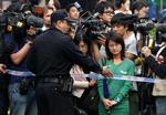 Holdt. En kinesisk politimand bremser  journalister, der forsøger at komme ind og få en kommentar fra nobelpristagerens hustru, Liu Xia, i Beijing. 