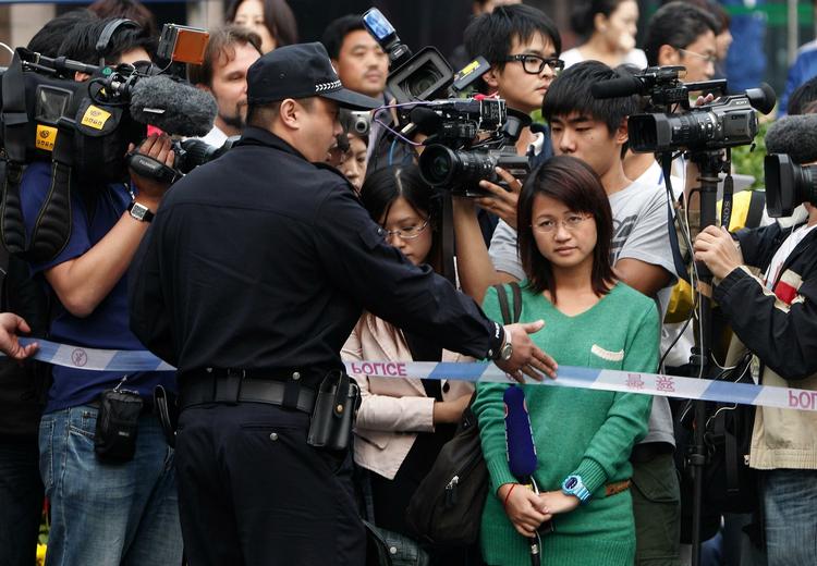Holdt. En kinesisk politimand bremser  journalister, der forsøger at komme ind og få en kommentar fra nobelpristagerens hustru, Liu Xia, i Beijing. 