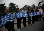 Hyldest. Tilhængere af Liu Xiaobo hylder ham og fredsprisen i en park i Beijing. 'Vi fejrer Lio Xiaobo som vinder af nobelprisen' står der på deres skilte. 