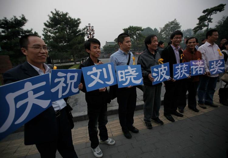 Hyldest. Tilhængere af Liu Xiaobo hylder ham og fredsprisen i en park i Beijing. 'Vi fejrer Lio Xiaobo som vinder af nobelprisen' står der på deres skilte. 