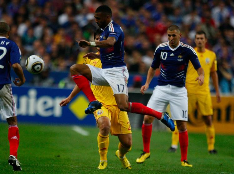 arbejdsro. Den franske midtbanespiller Yann M'Vila springer efter bolden foran Rumæniens Cristian Sapunarur i kampen i Frankrig. 