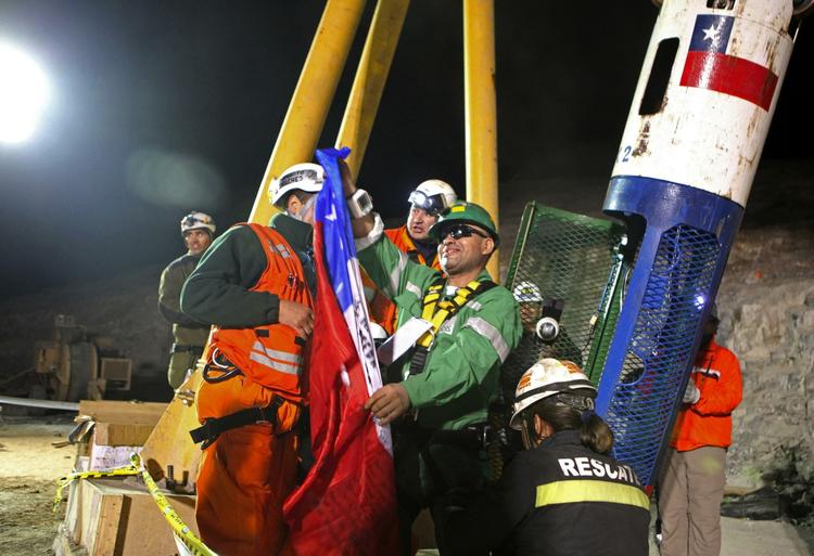 Jose Ojeda holder det Chilenske flag efter at være kommet ud af redningskapslen. 