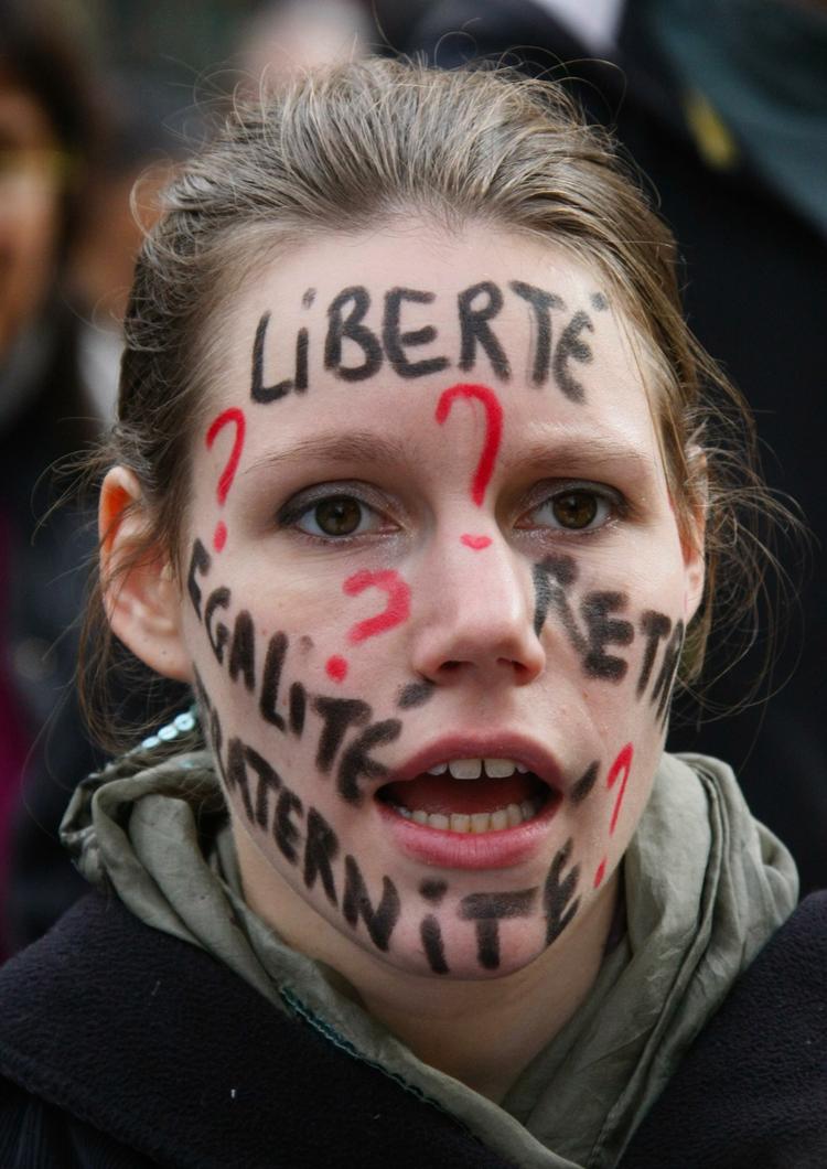 Frihed, lighed og broderskab står der på denne demonstrants ansigt. 
