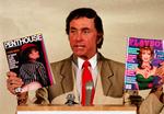 Penthousestifter Bob Guccione ses her på foto fra 1986 med et eksemplar af Penthouse i den ene hånd og rivalen Playboy i den anden. 
