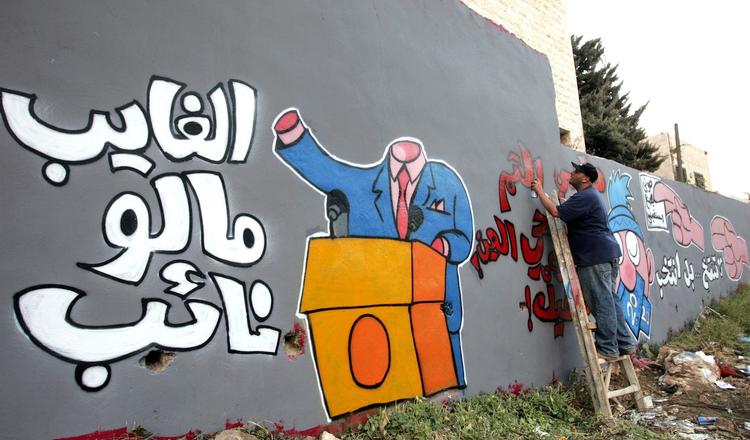 ytring. Jordansk kunstner arbejder på graffitiværk som led i en kampagne for mediebevidsthed. 