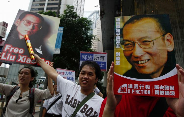 Pro-democracy protesters hold the picture of imprisoned Chinese dissident and Nobel Peace Laureate Liu Xiaobo with the words "Release Liu Xiaobo" as they march to China's Liaison Office in Hong Kong on Oct. 10. 