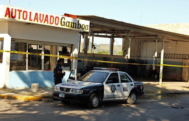 MASSAKRE. Politiet bevogter den bilvask i den mexicanske by Tepic, hvor 15 mennesker blev dræbt onsdag. 