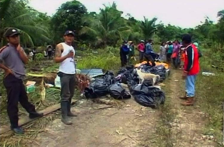 Døde. Redningsarbejdere udstyret med sorte ligposer er begyndt at nå frem til tsunami-ramte øer i Indonesien. 