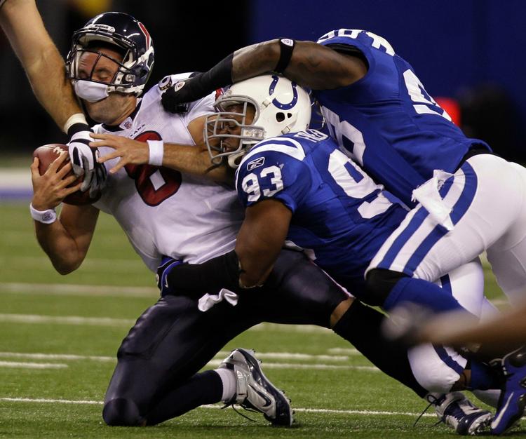 sacked. Houston Texans quarterback Matt Schaub bliver tacklet i afleveringsøjeblikket af fremstormende spillere fra Indianapolis Colts. 