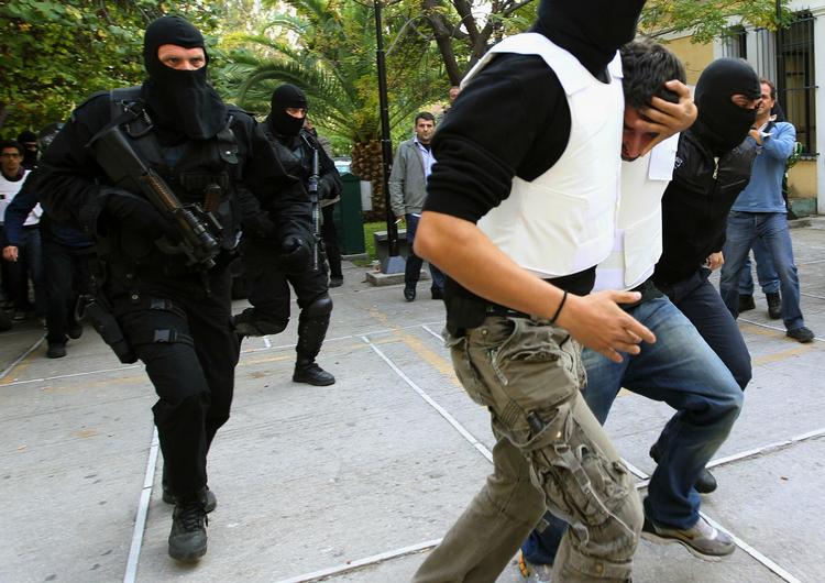 ANHOLDELSE. Terrormistænkt bringes til afhøring tirsdag efter fundet af en stribe pakkebomber i Grækenland. 