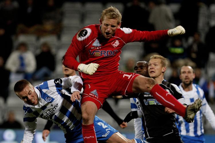 Odense. Randers' målmand, David Ousted, bokser bolden væk for næsen af hjemmeholdet OBs Espen Ruud i superligakampen i Odense mandag aften. 