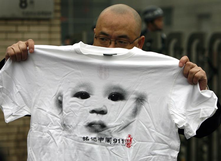 Protest. Zhao Llianhai har også designet protest T-shirts. Her holder en anden vred kineser en af hans trøjer ved en demonstration uden for en retsbygning i Beijing i marts i år. 