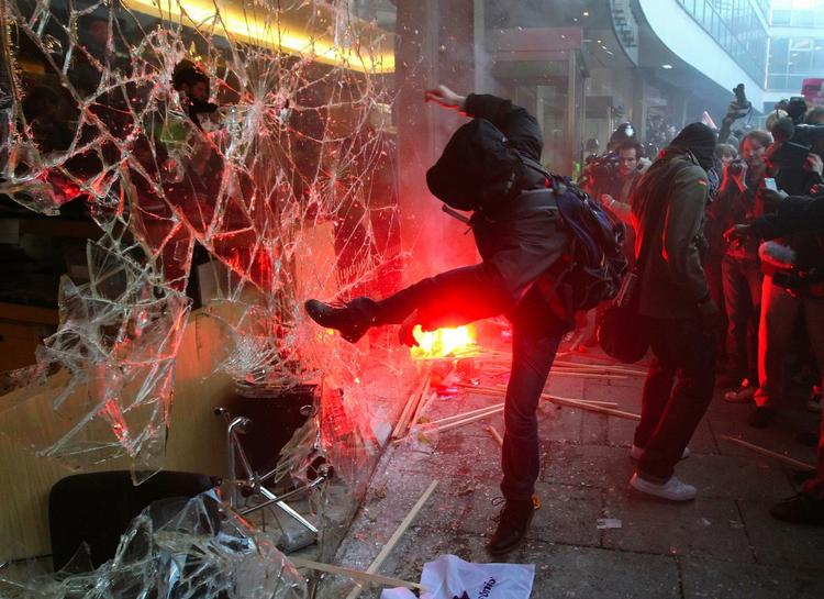 Knust. En demonstrant smadrer en rude i Millbank Tower i London, hvor de konservative har deres partikontor. 