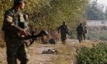 angreb. Afghanske soldater patruljerer forbi liget af en dræbt talebankæmper forklædt som afghansk soldat efter angrebet på den militære base i Jalalabad. 