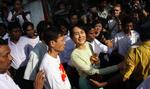 Fri. Aung San Suu Kyi smiler til sine tilhængere, da hun forlader partikontoret igen. 