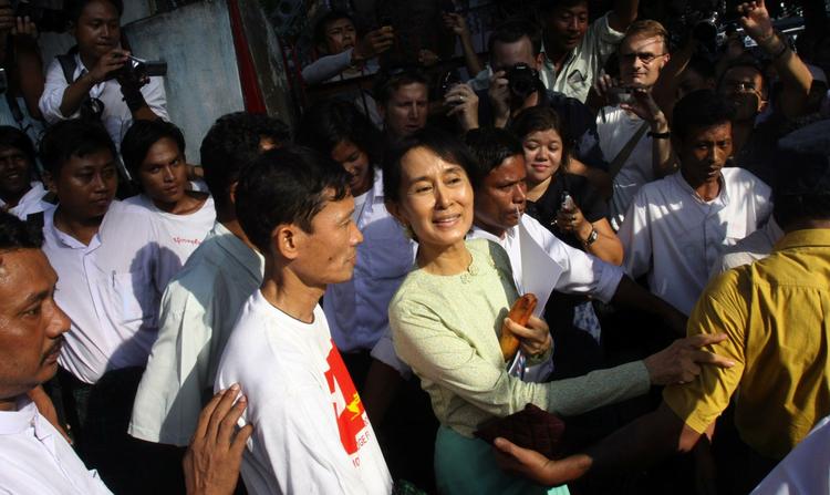 Fri. Aung San Suu Kyi smiler til sine tilhængere, da hun forlader partikontoret igen. 