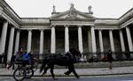 Presset. En hestevogn passerer 'Bank of Ireland', hvor medarbejderne bruger en hel del tid på at lede efter en løsning på en økonomiske krise. 