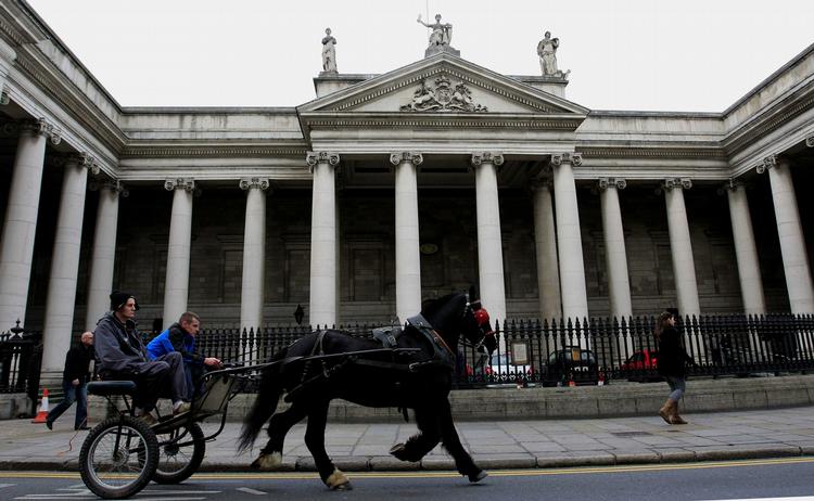 Presset. En hestevogn passerer 'Bank of Ireland', hvor medarbejderne bruger en hel del tid på at lede efter en løsning på en økonomiske krise. 