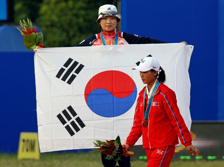 symbolik. Nordkoreaneren går slukøret forbi den sydkoreanske guldvinder. 