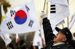 Demonstranter protesterer mod det nordkoreanske angreb foran forsvarsminesteriet i Seoul. 