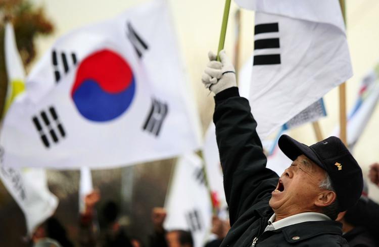 Demonstranter protesterer mod det nordkoreanske angreb foran forsvarsminesteriet i Seoul. 