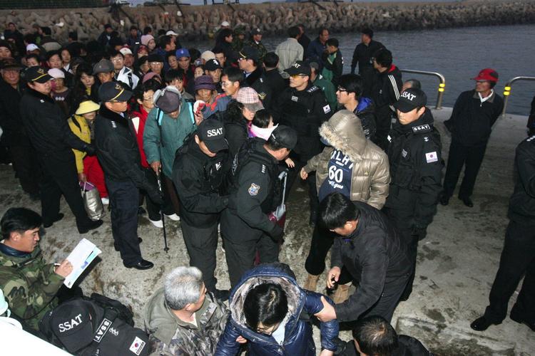 Flugt. Beboere på Yeonpyeong venter på at komme om bord på et skib, der skal fragte dem til sydkoreansk fastland. 