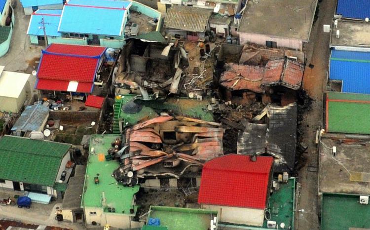 ANGREB. Luftfoto viser ødelagte huse på Yeonpyeong-øen efter den nordkoreanske beskydning. 
