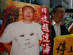 Protests. A pro-democracy protester holds the picture of Zhao Lianhai during a demonstration at the China Liaison Office in Hong Kong. 