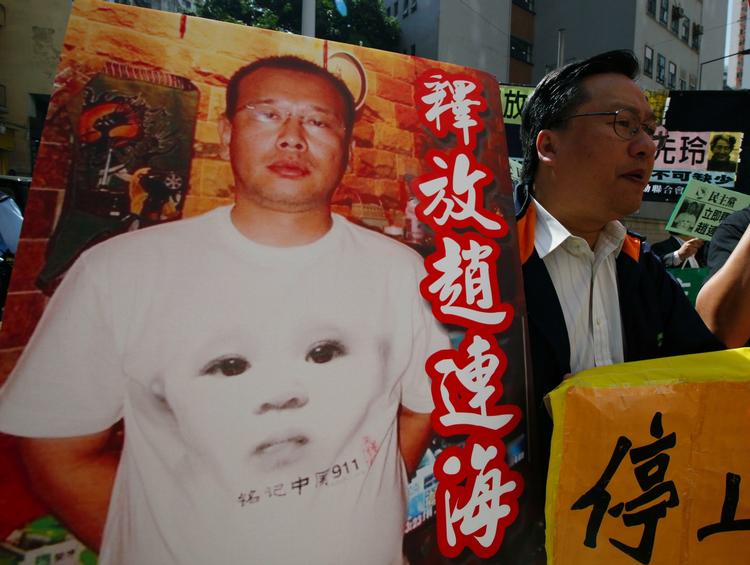 Protests. A pro-democracy protester holds the picture of Zhao Lianhai during a demonstration at the China Liaison Office in Hong Kong. 