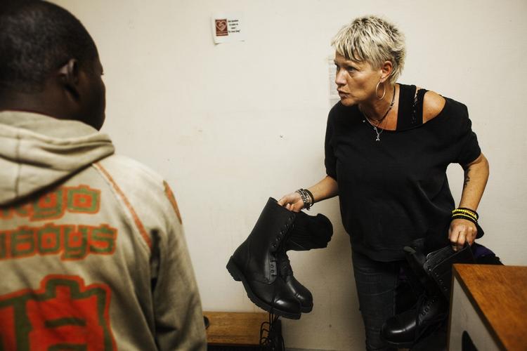 Uddeling. Der var ikke sko nok til alle, men nogle var heldige at få erstattet plastiksandalerne. Her er det en frivillig der uddeler militærstøvler doneret af forsvaret. 