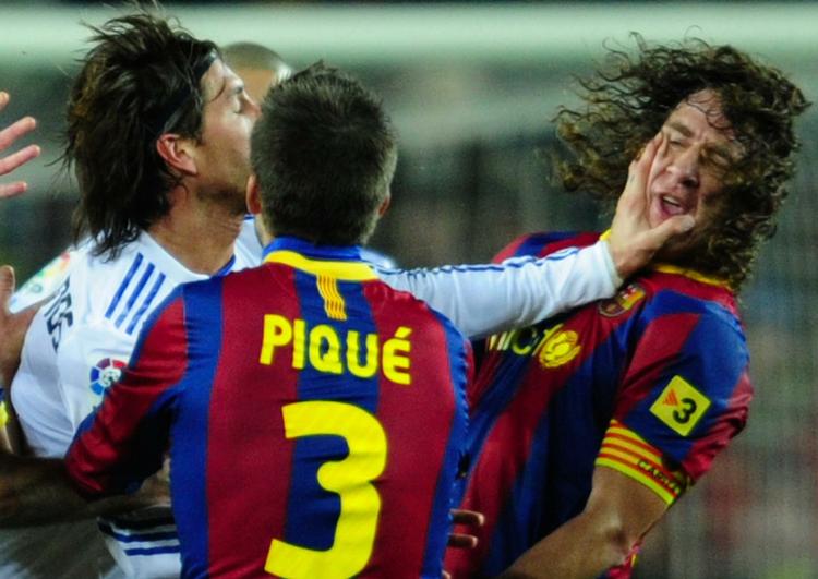 Real Madrids Sergio Ramos kæmper med  FC Barcelonas Carles Pujol. 