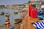 Badeforbud. Sharm el-Sheikh i dag. Turister solbader og spejder ud over havet, mens det røde flag signalerer badeforbud efter flerer hajangreb. 