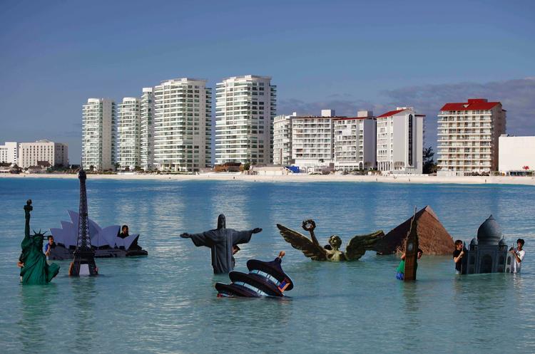 Demonstration. Aktivister fra Greenpeace viser i Cancún, hvordan kloden er truet af højere vandstande. 