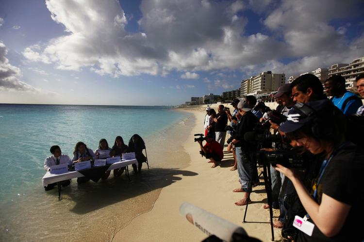 Klimaaktivister holder pressemøde på stranden i Cancún. 