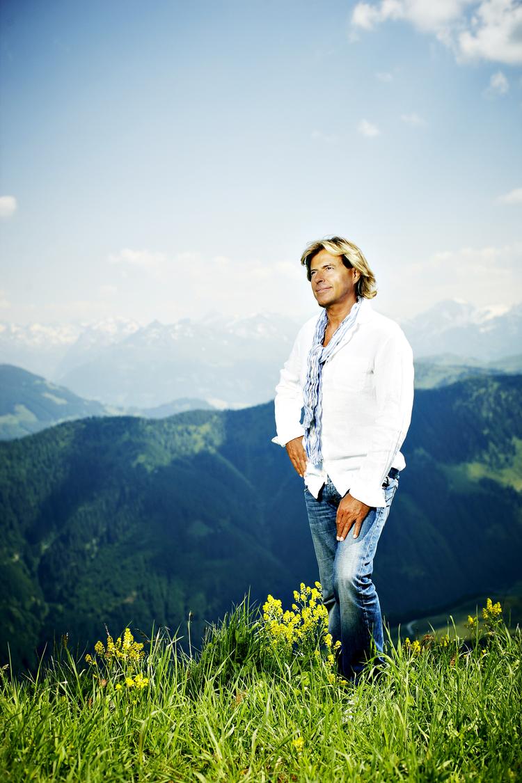 Hansi Hinterseer i sit rette element. Med Alperne i baggrunden og så rene negle, så det ligner fransk manicure. Hvert år inviterer han sine fans på vandretur i bjergene. De kvitterer ved at strikke strømper, som de overrækker til idolet ved hans årlige hjemkomstkoncert i Kitzbühel, 'Hansi Hinterseer im Open Air'. PR-foto 