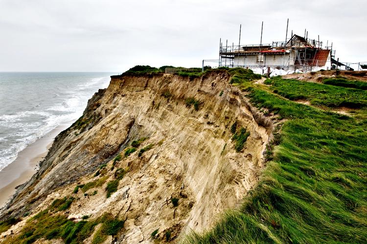 erosion. Havet har ædt sig så meget ind på visse danske kyststrækninger, at man i 2008 måtte fjerne Mårup Kirke  i Nordjylland, før den skred ned ad skrænten. 