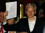 Assange. WikiLeaks founder Julian Assange holds up a court document for the media after he was released on bail, outside the High Court, London, Thursday, Dec. 16, 2010. 