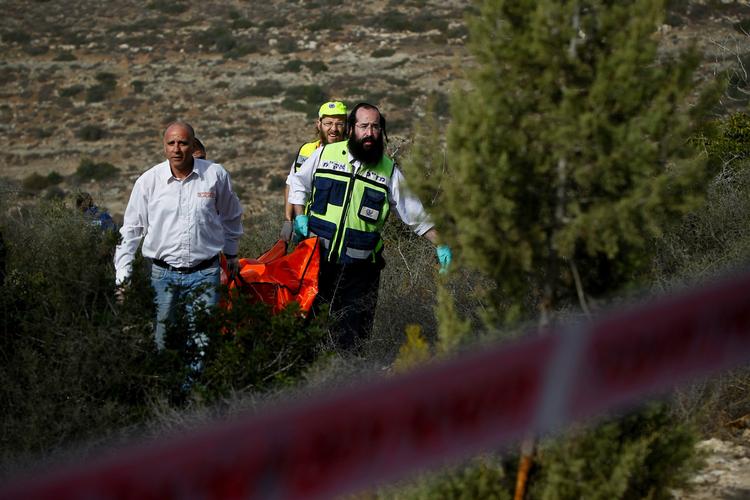 Dræbt. Israelske redningsarbejdere bærer liget af den amerikanske turist Christine Logan efter hun blev fundet dræbt i et skovområde uden for Jerusalem. 