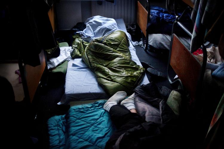 Herberget "En Varm Seng" har, som et af de eneste herberger i Danmark, åbnet dørene for udenlandske hjemløse. Dette skabte så meget røre, at socialminister Benedikte Kjær (K) med to en halv times varsel d. 3 december, meldte sin ankomst til herberget, for at få en rundvisning af leder April Chris. Besøget endte i åbent skænderi mellem de to kvinder og få dage efter blev omtrent 70 mennesker anholdt da politiet rykkede ind en nat. Billedet er taget klokken ni om morgen, og flere har fundet plads på gulvet, da alle senge er fyldte. 