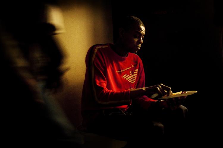 Herberget "En Varm Seng" har, som et af de eneste herberger i Danmark, åbnet dørene for udenlandske hjemløse. Dette skabte så meget røre, at socialminister Benedikte Kjær (K) med to en halv times varsel d. 3 december, meldte sin ankomst til herberget, for at få en rundvisning af leder April Chris. Besøget endte i åbent skænderi mellem de to kvinder og få dage efter blev omtrent 70 mennesker anholdt da politiet rykkede ind en nat. Olando Gaspar Brancoi, 24 år, spiser sin morgenmad på herberget "En Varm Seng". Olando har boet alle sine tre måneder i Danmark på herberget. Han har før boet 7 år i Spanien, men er oprindeligt fra øen Sao Tome Principe i Afrika. Olando er her for at finde arbejde. 