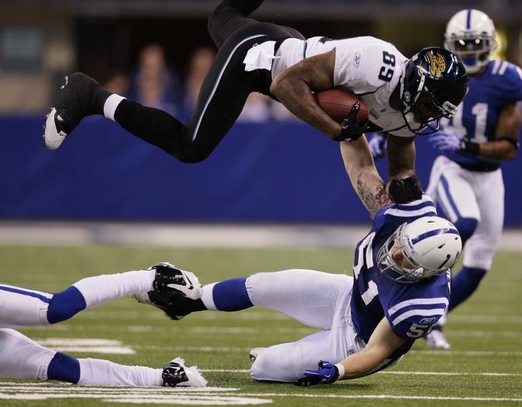 flyvende. Jacksonville Jaguars Marcedes Lewis bliver tacklet højt op i luften af Indianapolis Colts Pat Angerer under kampen søndag aften. 