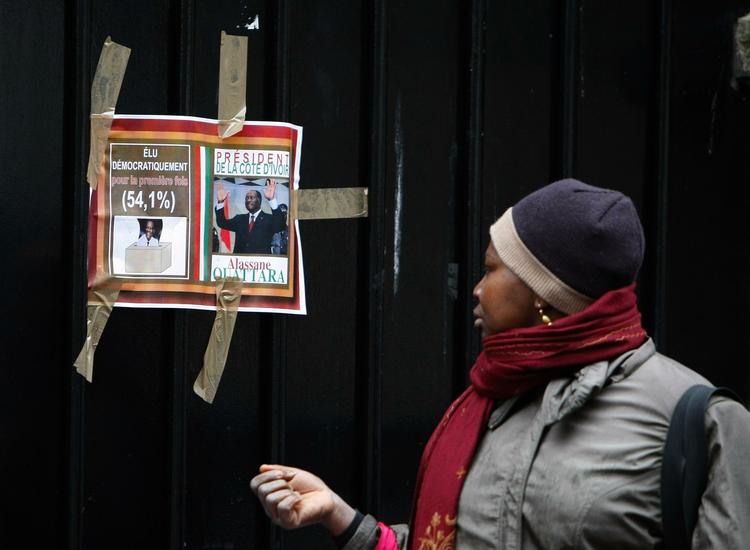 Lukket. En kvinde passerer en plakat på porten til Elfenbenskystens ambassade i Paris. Ambassaden lukkede i går, dagen efter at den midlertidigt var blevet overtaget af personer, som støtter Alassane Ouattara, der af det internationale samfund er udråbt til vinder af præsidentvalget. 